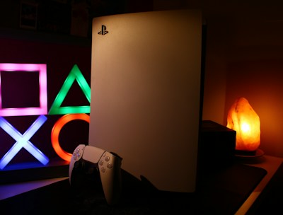 a video game console sitting next to a neon sign