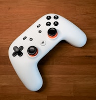 a white controller sitting on top of a wooden floor